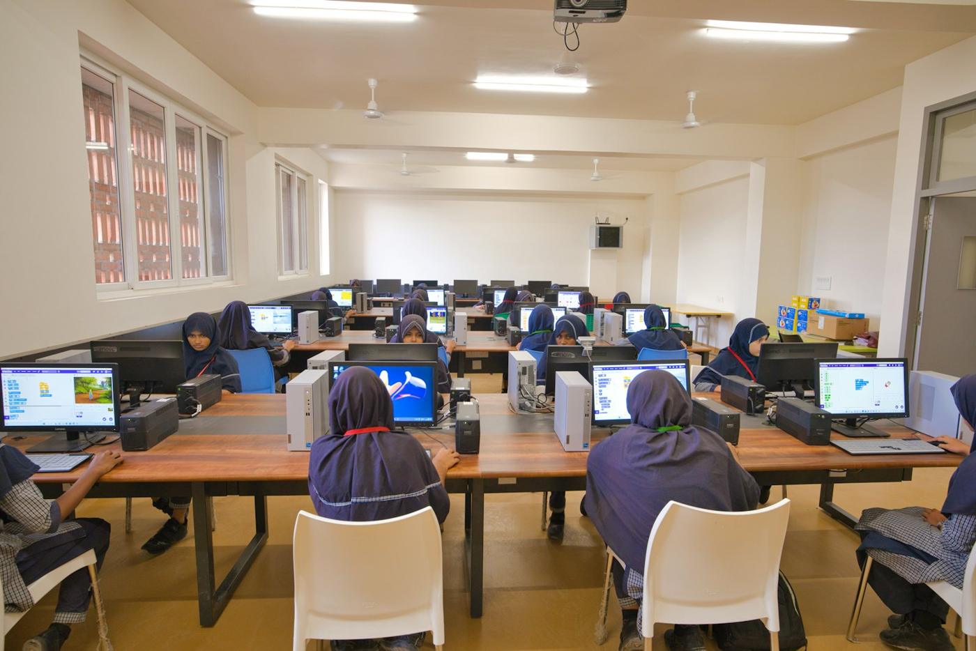 Students working at computers in a bright classroom